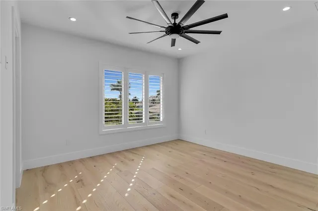 an empty room with a window and a fan