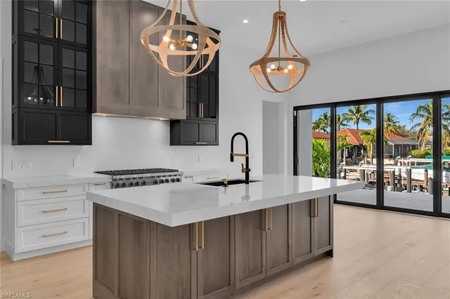 a very nice looking kitchen with granite countertop a stove a sink and a refrigerator