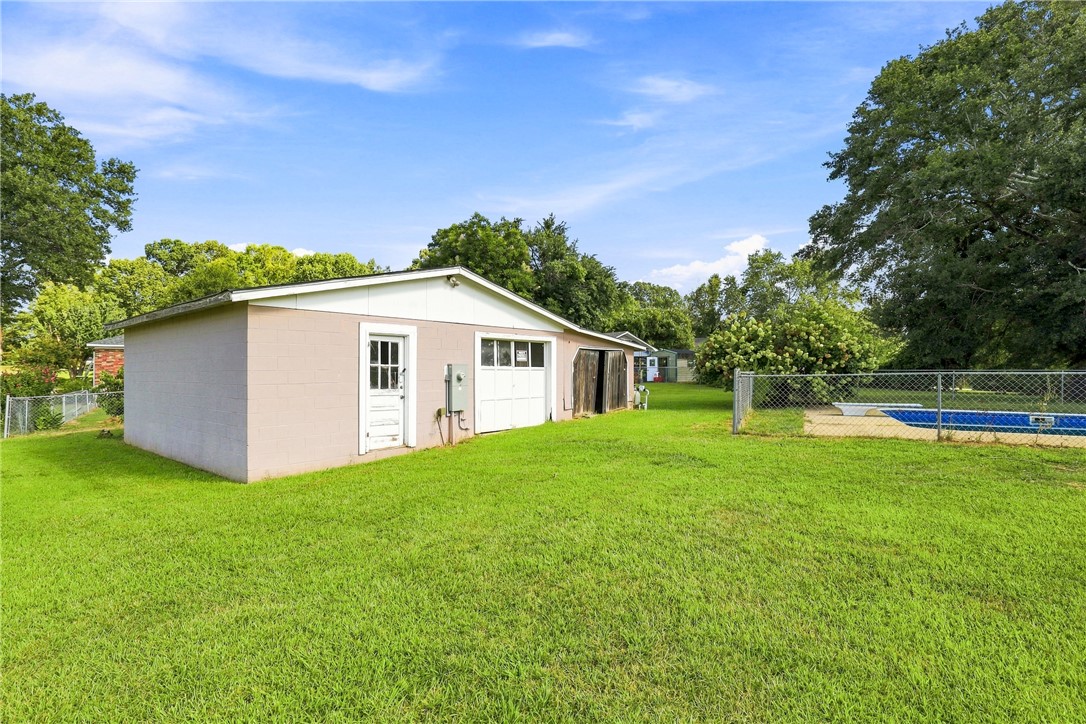 205 Timms Road Piedmont, SC 29673 - Photo 24 of 36 A spacious green lawn borders a detached outbuilding and a fenced backyard swimming pool.