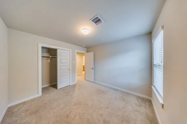an empty room with closet and bathroom