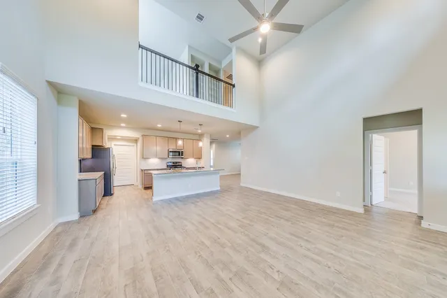 a open kitchen with stainless steel appliances kitchen island a large counter top and a wooden floor