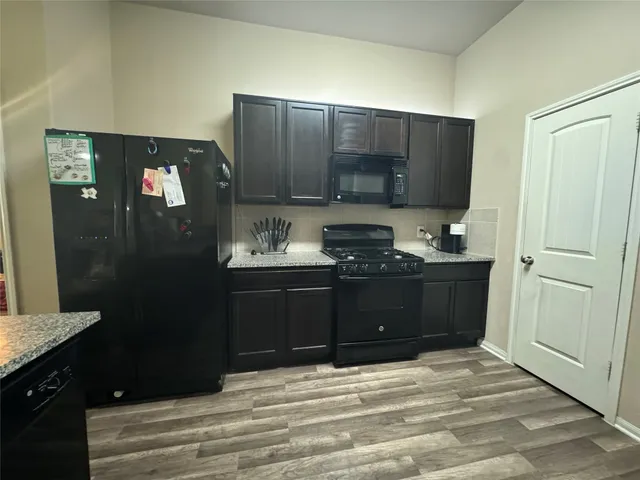 a kitchen with a refrigerator and a stove