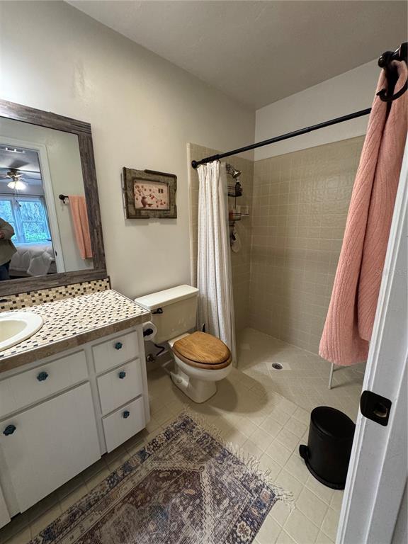 4623 Southwest 83 Drive Gainesville, FL 32608 - Photo 22 of 29 a bathroom with a granite countertop sink toilet a mirror and shower
