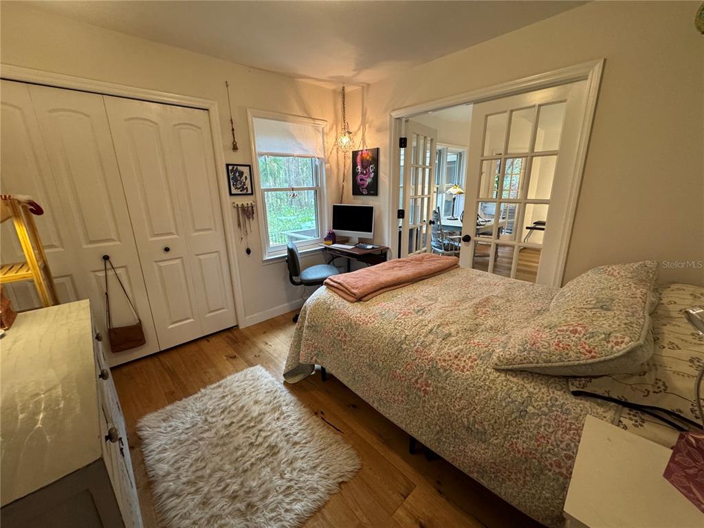 4623 Southwest 83 Drive Gainesville, FL 32608 - Photo 23 of 29 a bedroom with a bed and wooden floor