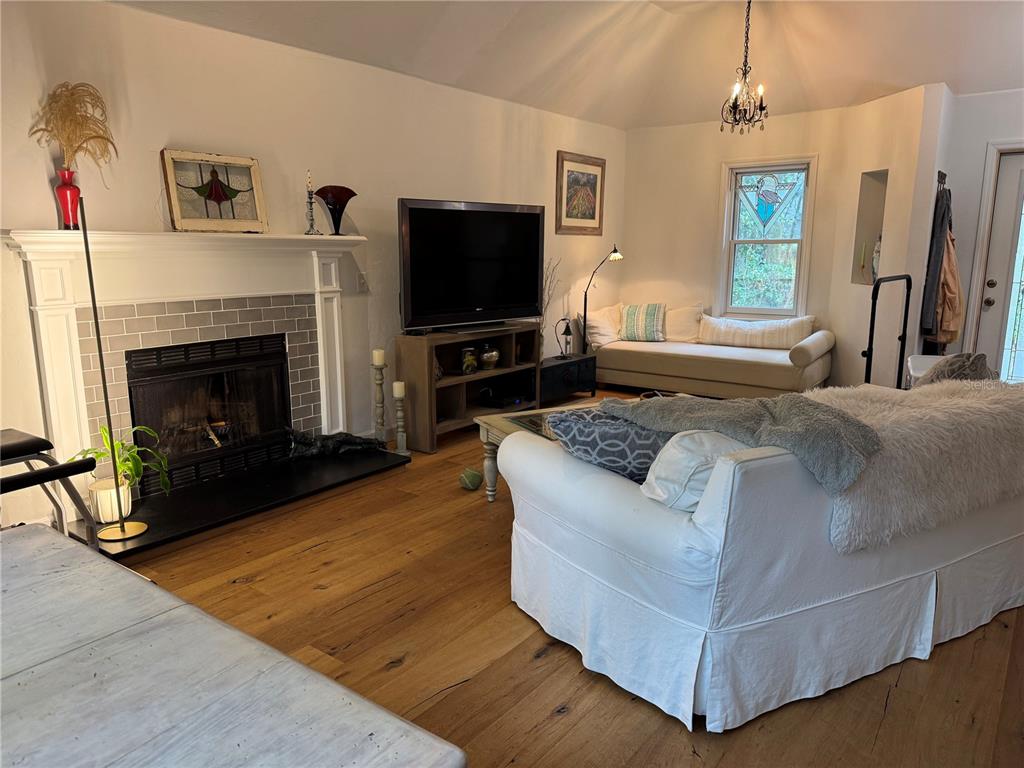 4623 Southwest 83 Drive Gainesville, FL 32608 - Photo 3 of 29 a living room with furniture a flat screen tv and a fireplace