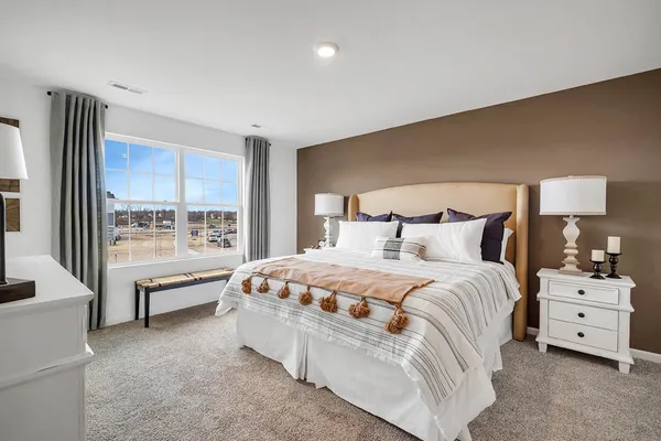 a spacious bedroom with a bed and a large window