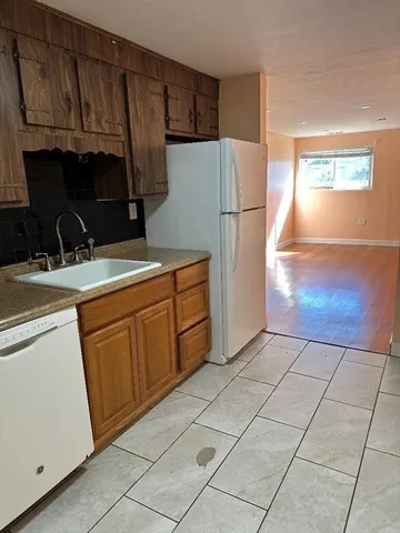 a kitchen with a refrigerator sink stove and cabinets