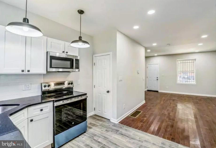 a kitchen with wooden floor cabinets and a wooden floor
