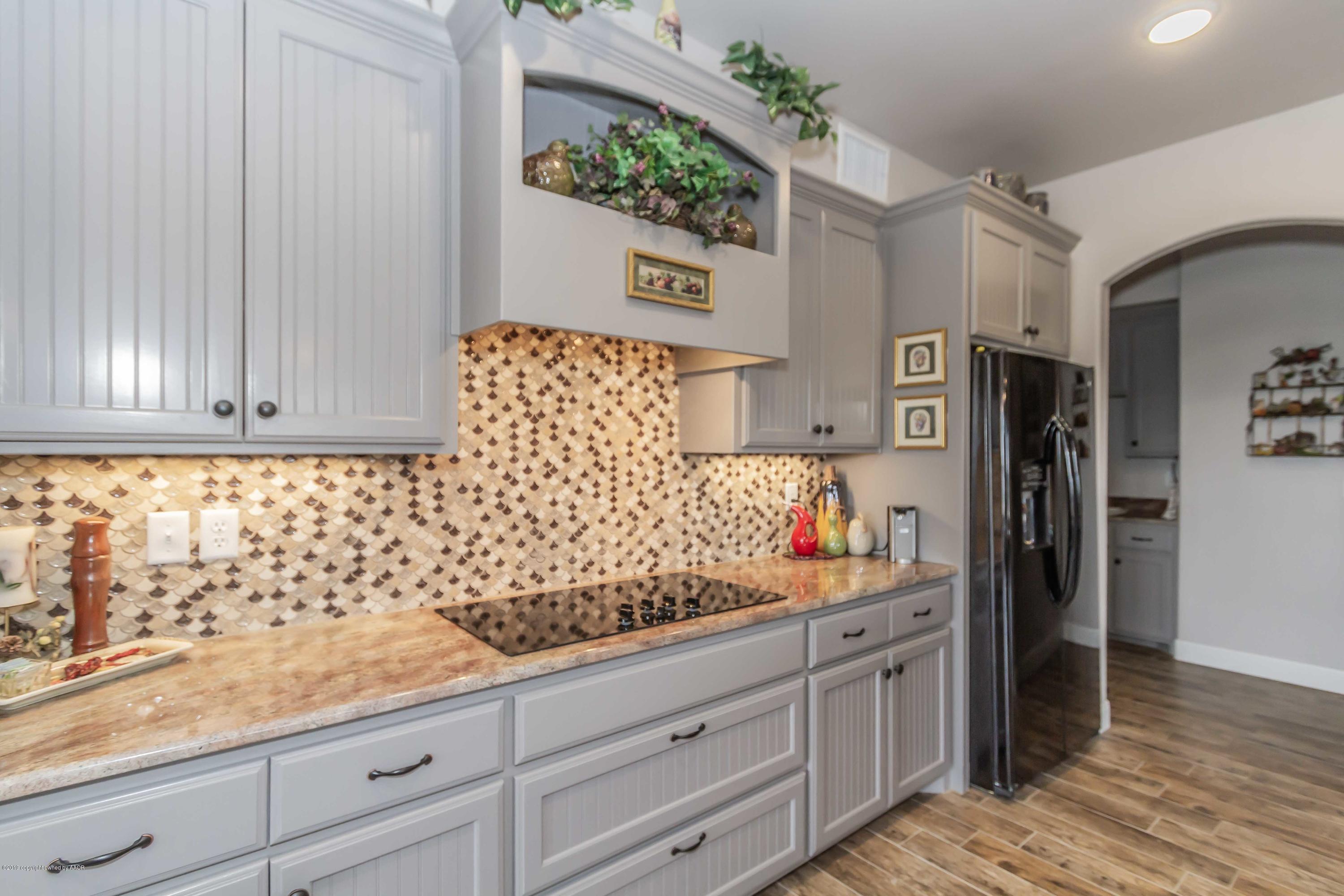 305 Mourning Dove Road Canyon, TX 79015 - Photo 17 of 65 a kitchen with granite countertop white cabinets and stainless steel appliances