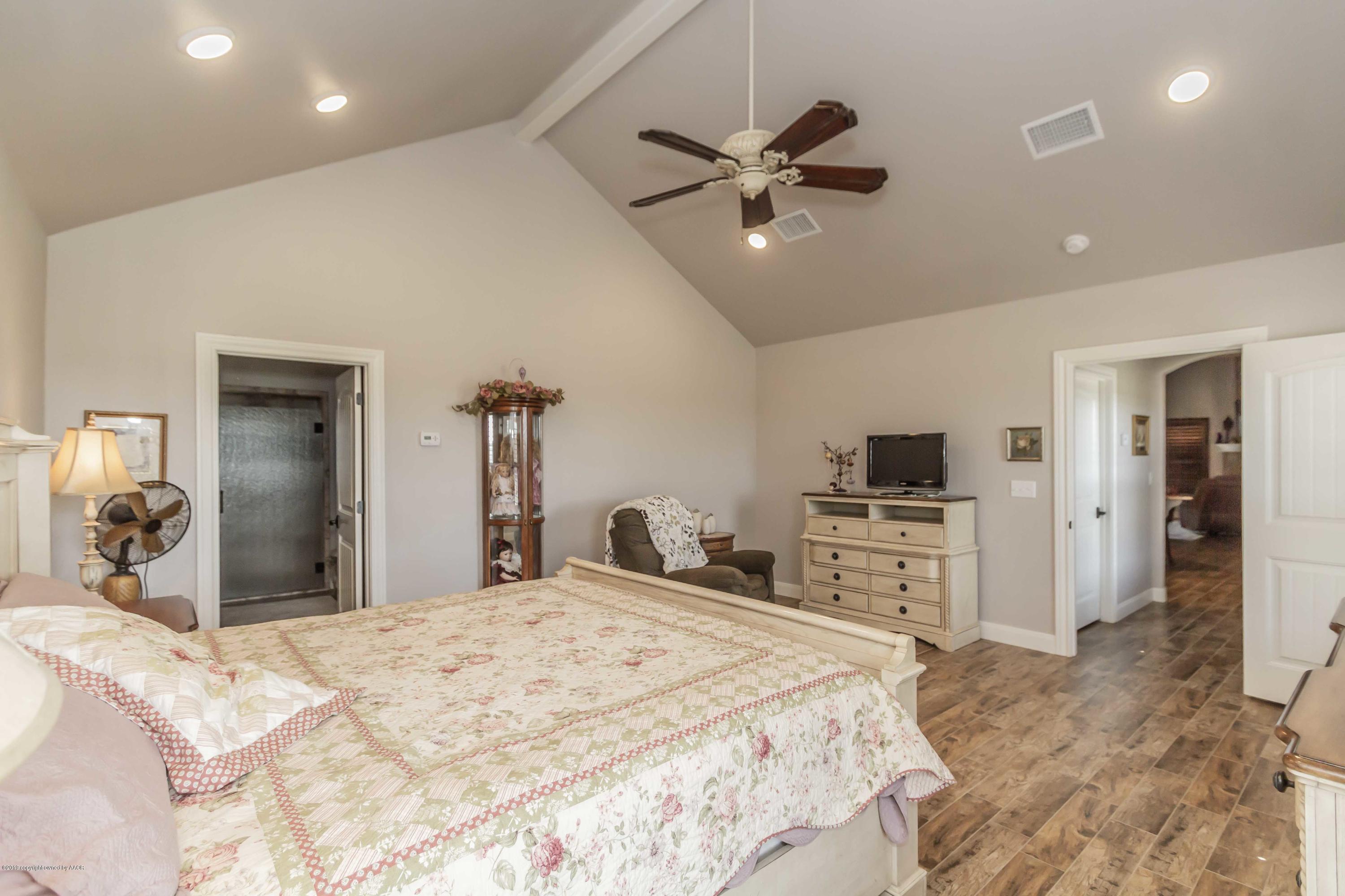 305 Mourning Dove Road Canyon, TX 79015 - Photo 29 of 65 a bedroom with a bed and a chandelier