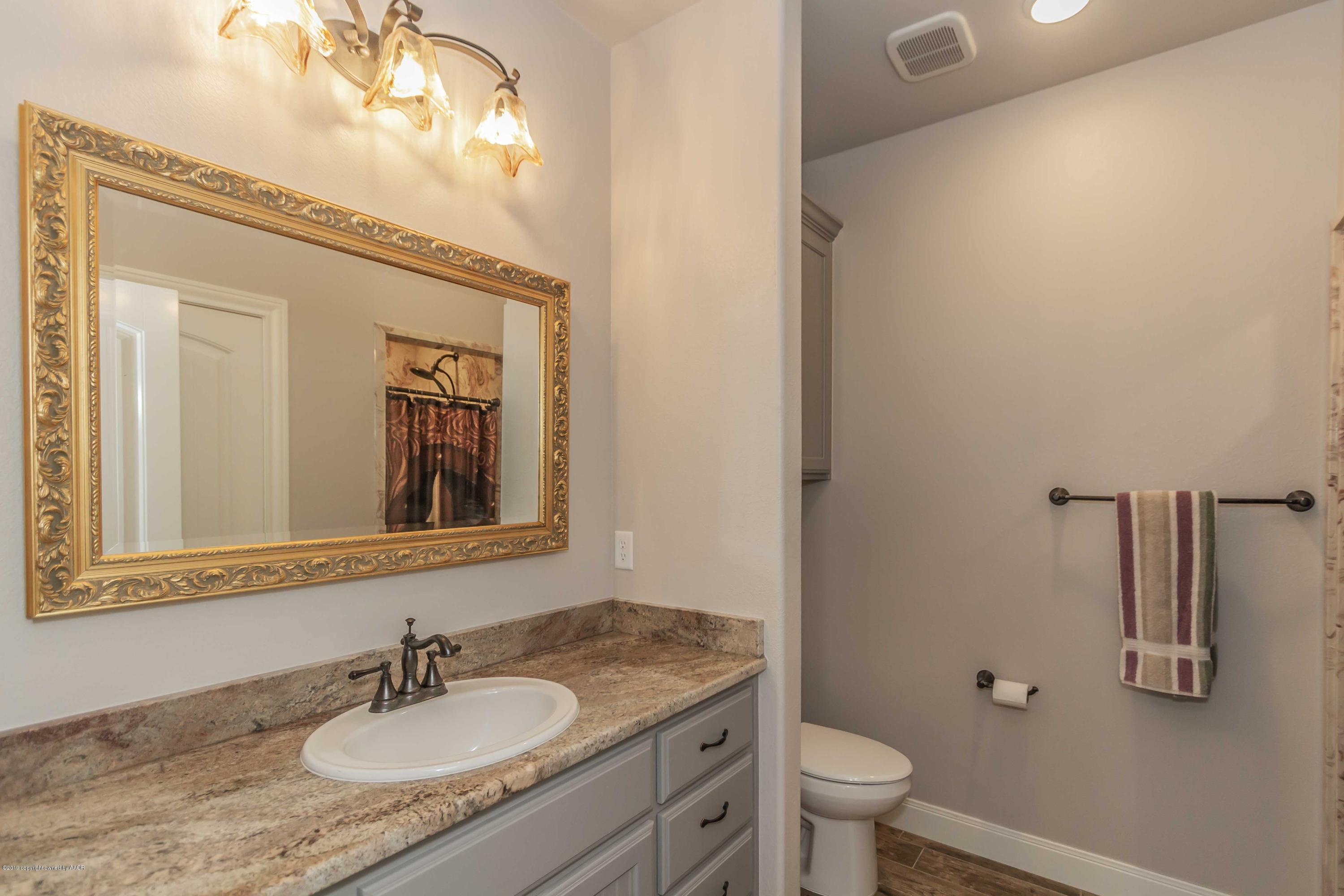 305 Mourning Dove Road Canyon, TX 79015 - Photo 50 of 65 a bathroom with a granite countertop sink toilet and mirror