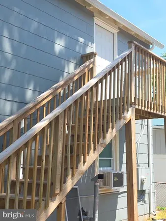 a view of staircase with railing and white walls