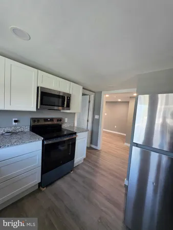 a kitchen with wooden floors and stainless steel appliances
