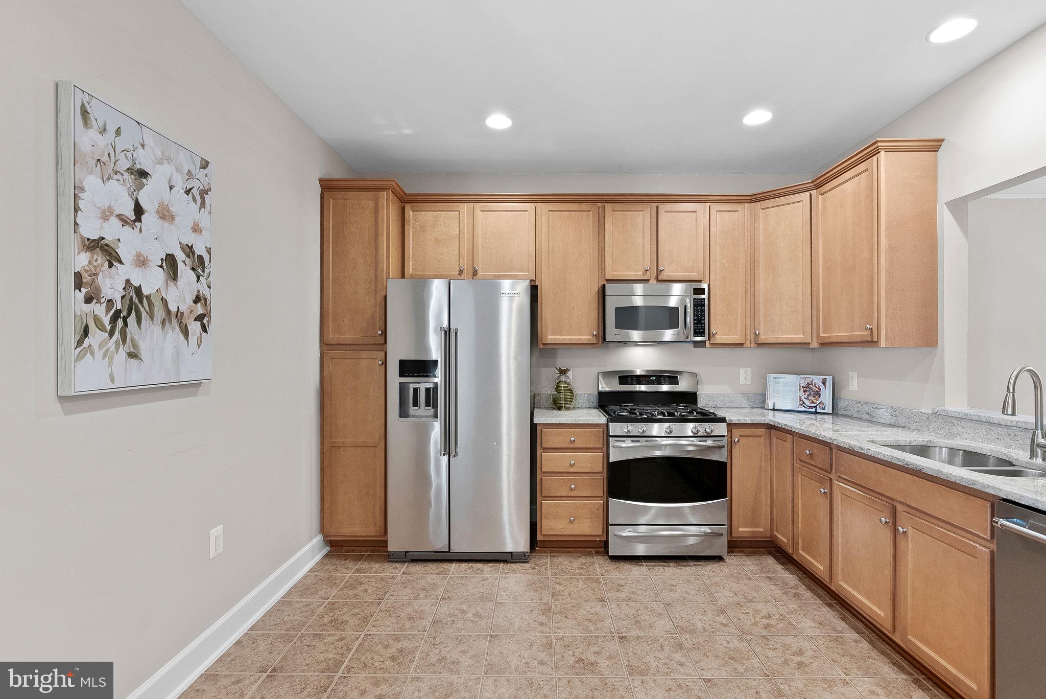 44424 Sunset Maple Drive Ashburn, VA 20147 - Photo 13 of 63 a kitchen with stainless steel appliances granite countertop a refrigerator a stove a sink and a microwave