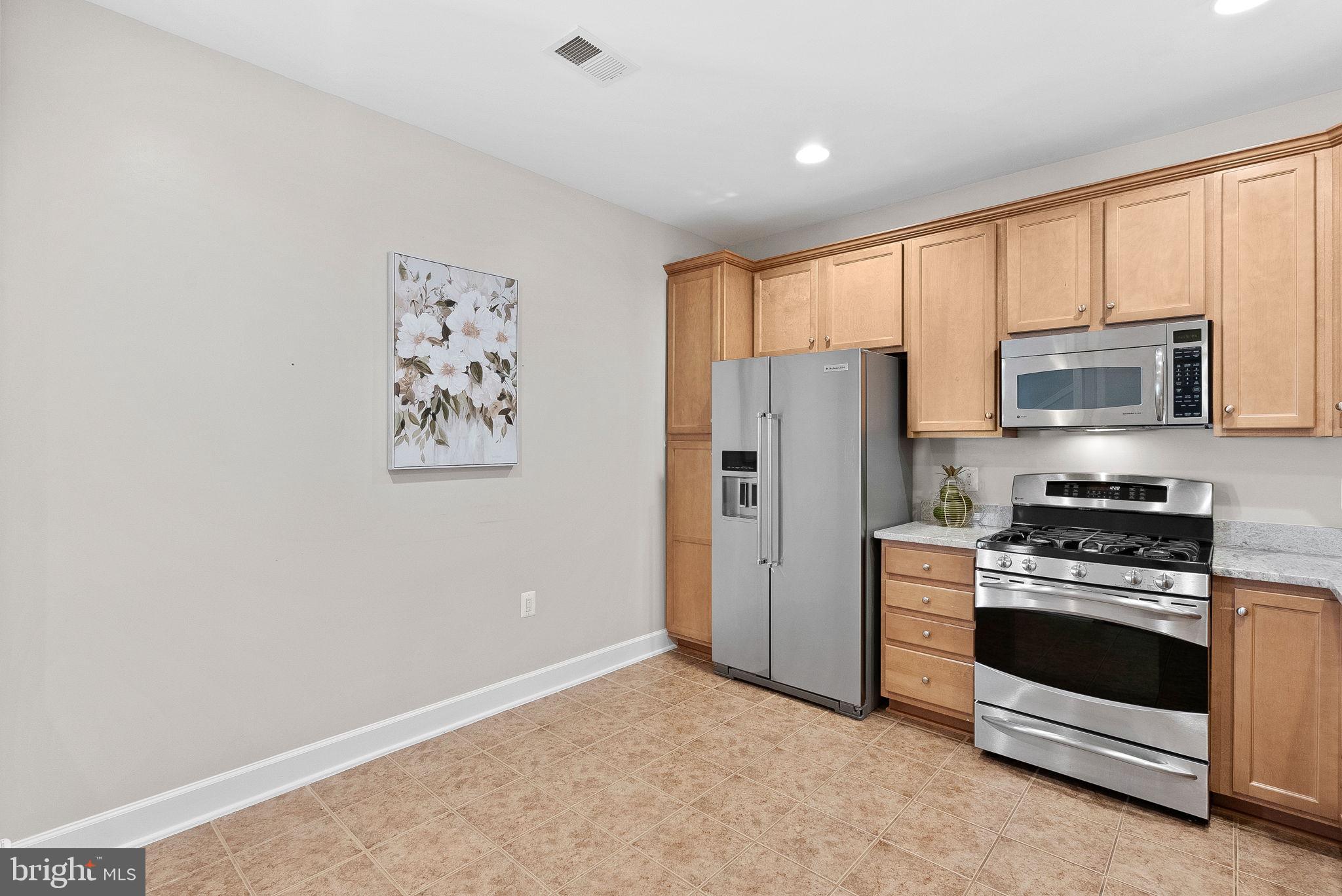 44424 Sunset Maple Drive Ashburn, VA 20147 - Photo 14 of 63 a kitchen with stainless steel appliances a refrigerator stove and microwave