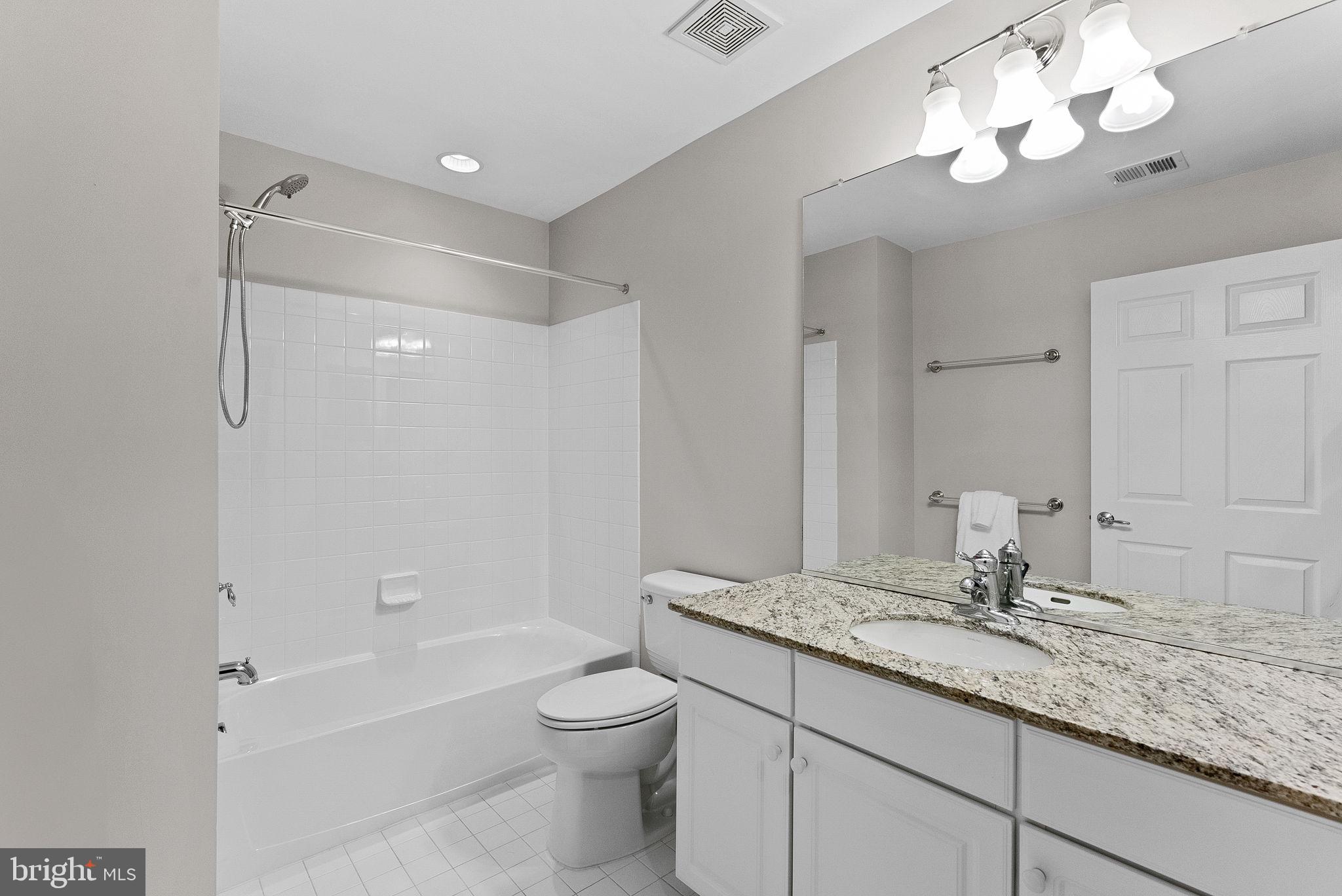 44424 Sunset Maple Drive Ashburn, VA 20147 - Photo 44 of 63 a bathroom with a granite countertop sink a toilet and shower