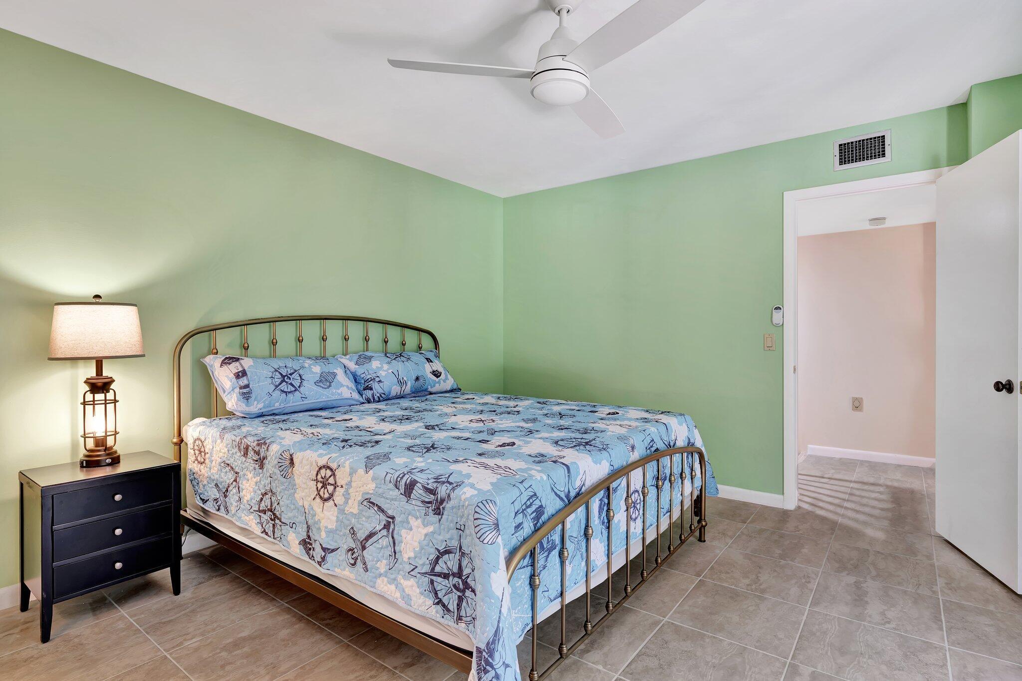 3016 30th Court Jupiter, FL 33477 - Photo 6 of 8 a bedroom with a bed and a chandelier