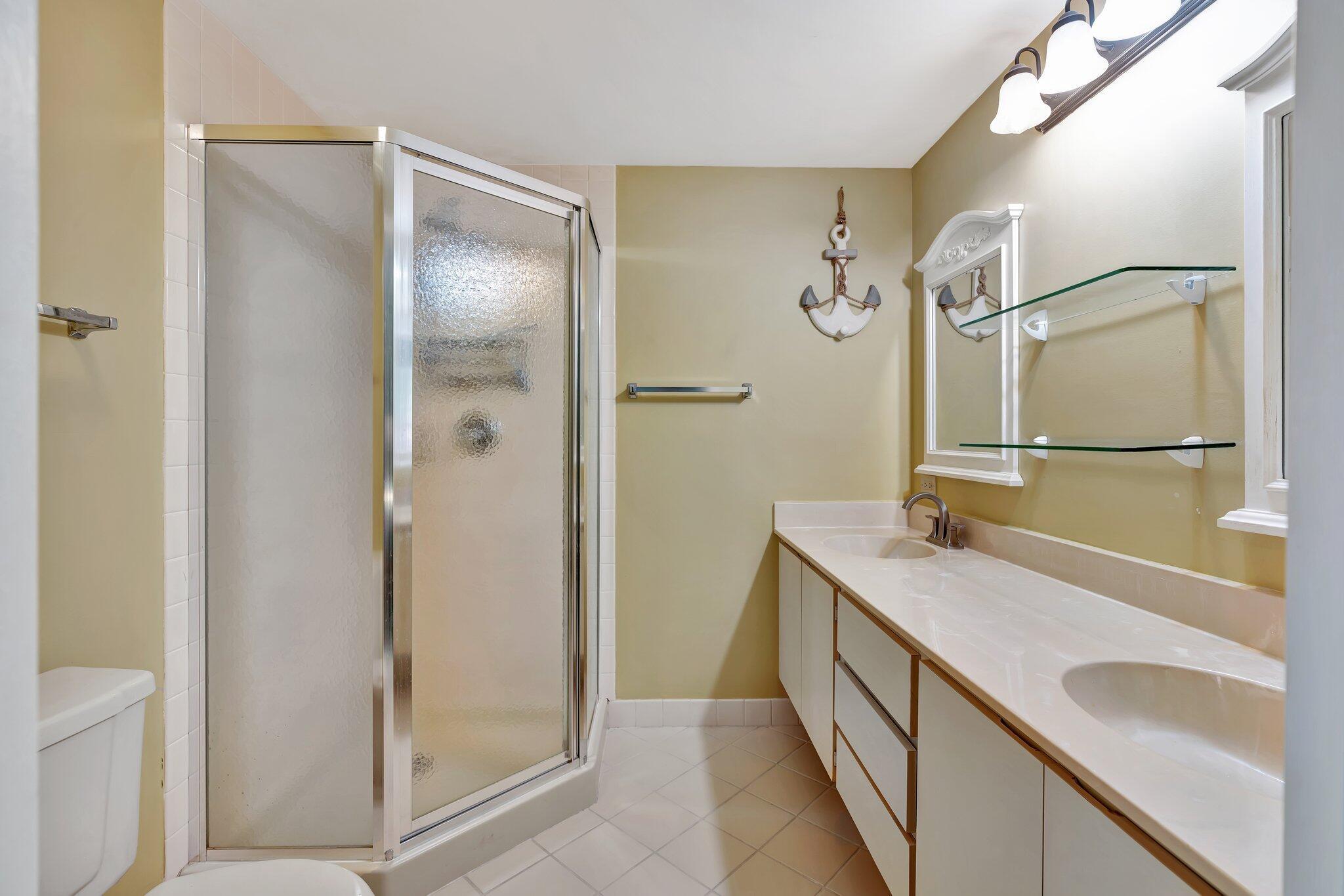3016 30th Court Jupiter, FL 33477 - Photo 7 of 8 a bathroom with a granite countertop sink a mirror and a shower
