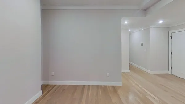 a view of an empty room with wooden floor