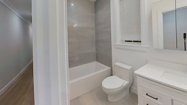 a white toilet sitting next to a bath tub