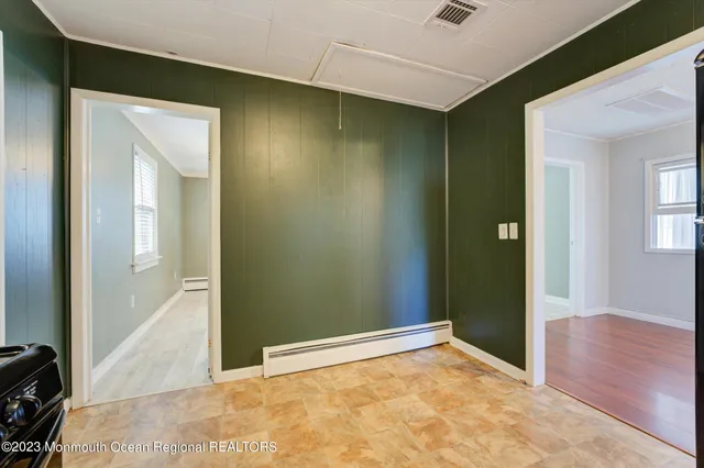 a view of a big room with wooden floor and windows