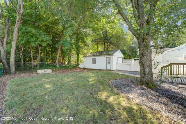 a view of a house with backyard and a tree