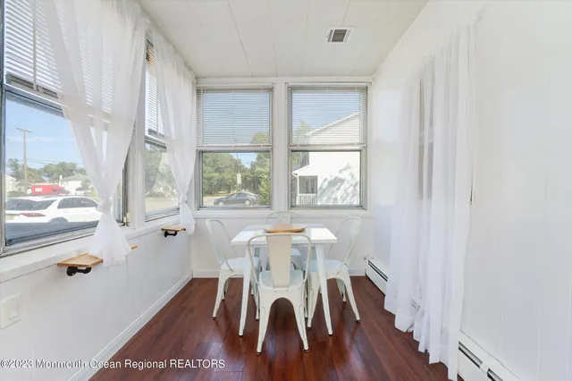 a view of a dining room with furniture a chandelier and wooden floor