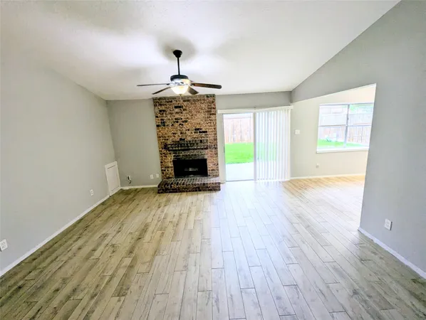 a view of empty room with a window and wooden floor