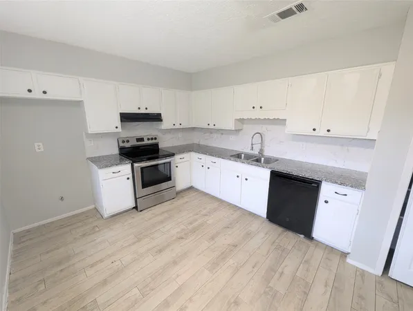 a kitchen with granite countertop a sink and cabinets