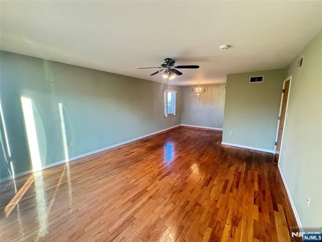 a view of a big room with wooden floor and a ceiling fan