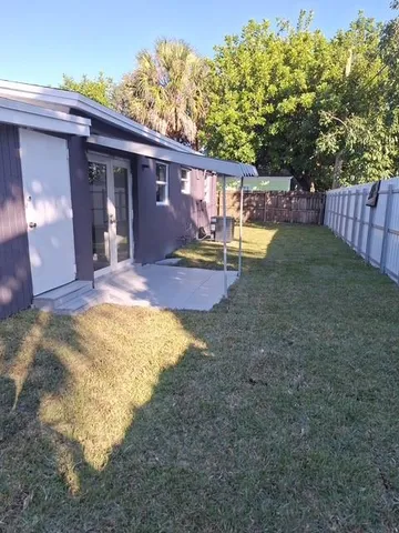 a view of a house with backyard and sitting area