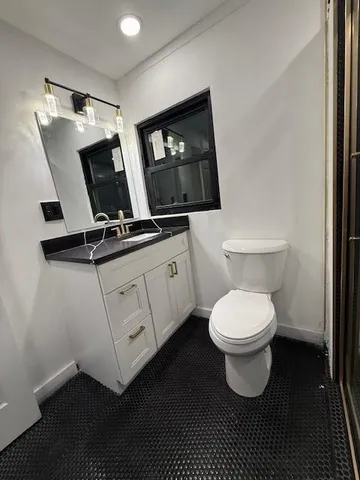 a bathroom with a toilet sink and mirror