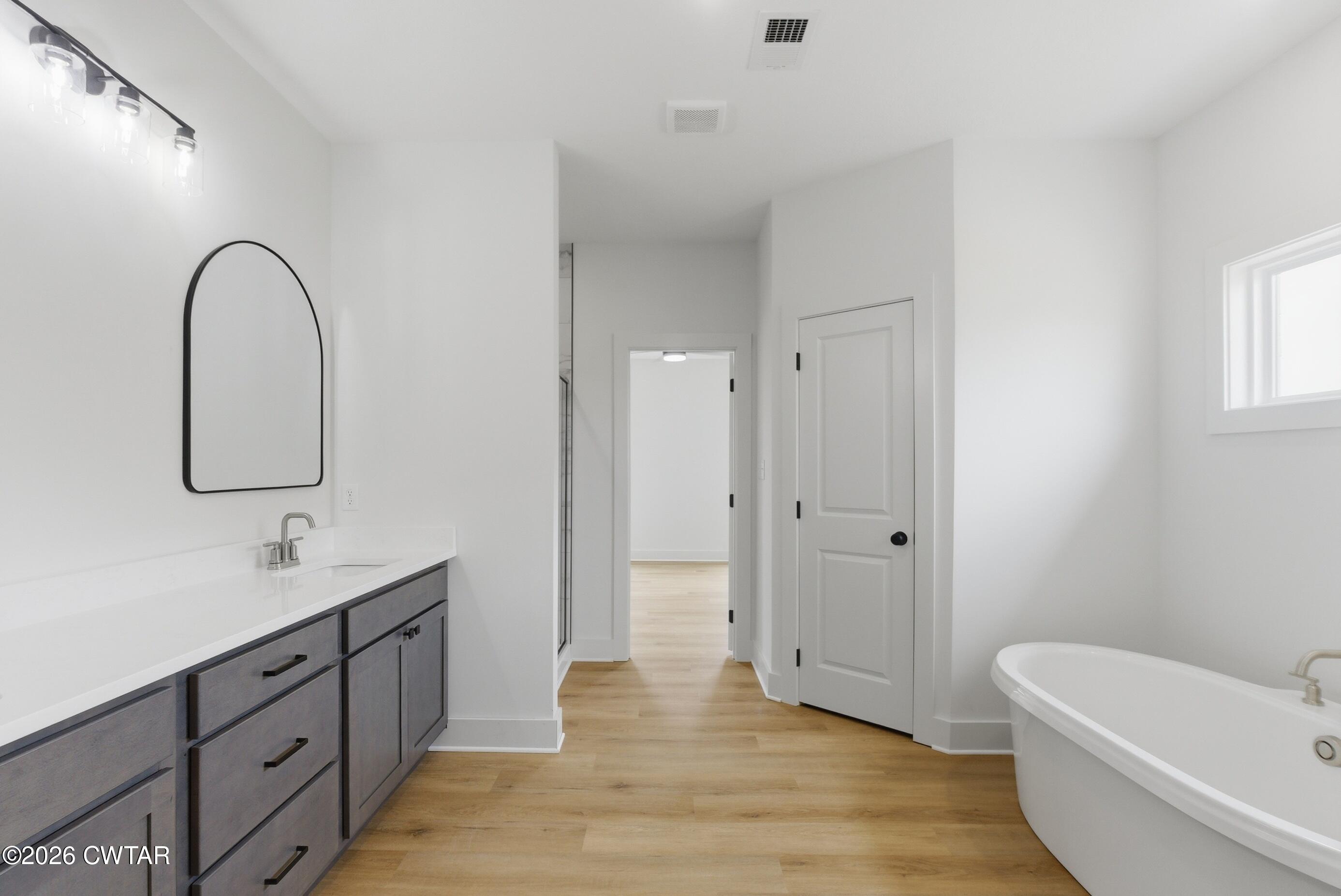 179 Daybreak Loop Medina, TN 38355 - Photo 15 of 32 a spacious bathroom with a double vanity sink a toilet and a mirror