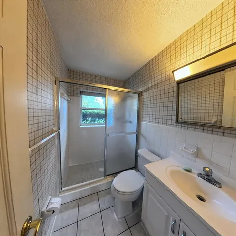 a bathroom with a sink a toilet a mirror and shower