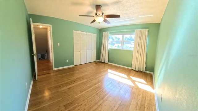 a view of an empty room with window and a bathroom