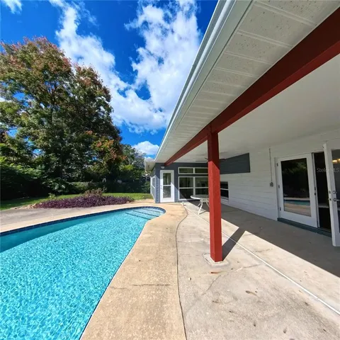 a patio with table and chairs and potted plants