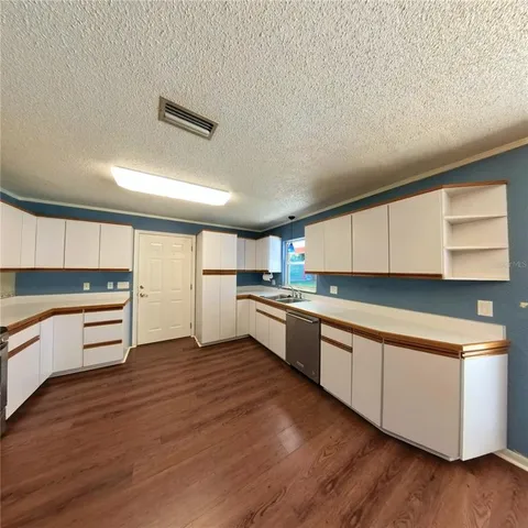 a kitchen with a cabinets and wooden floor