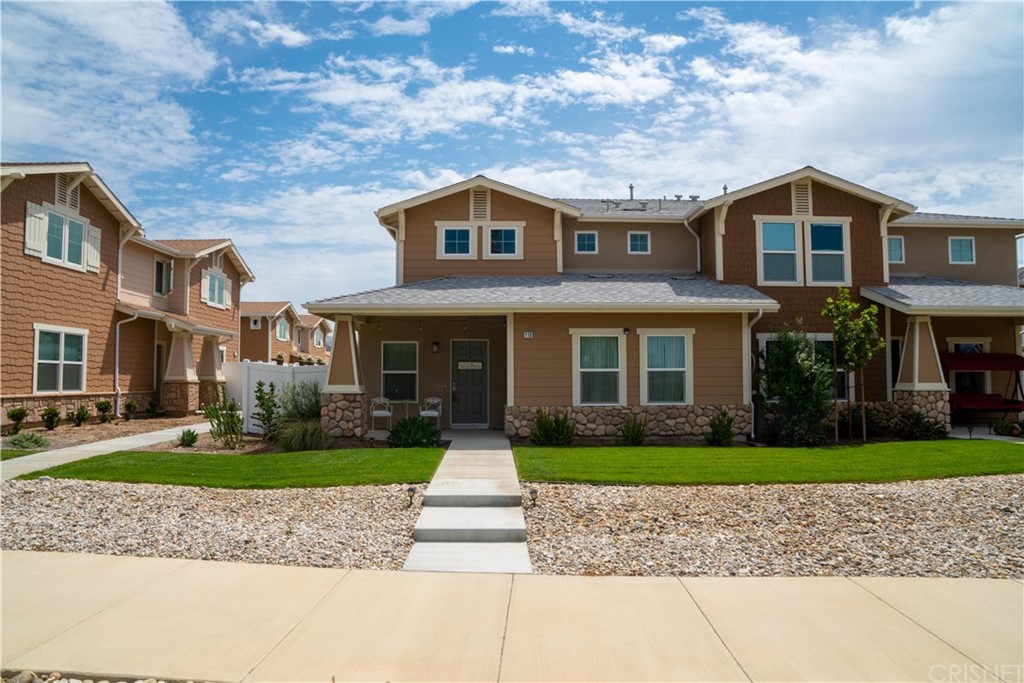 a front view of a house with a yard and potted plants