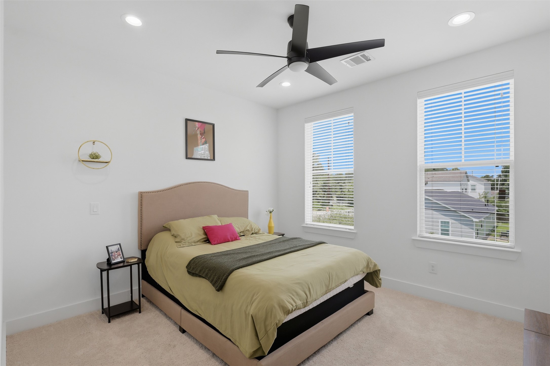 6833 Paris Street Houston, TX 77021 - Photo 15 of 23 Bright bedroom with large windows, neutral carpet, and modern ceiling fan. Features a cozy bed with a stylish headboard and minimal decor.