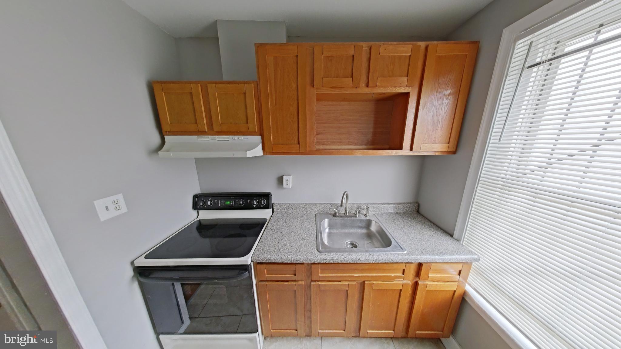 2255 North Cleveland Street Philadelphia, PA 19132 - Photo 4 of 9 a kitchen with a sink a stove and cabinets