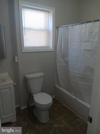 a white toilet sitting next to a window