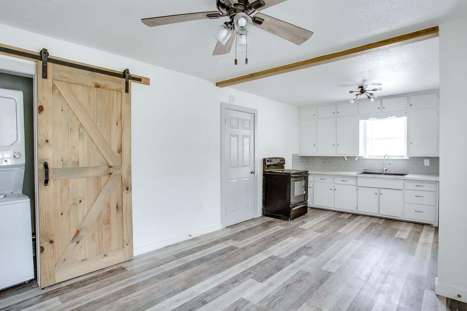 3414 24th Street Lubbock, TX 79410 - Photo 13 of 18 a kitchen with stainless steel appliances a white cabinets and wooden floor