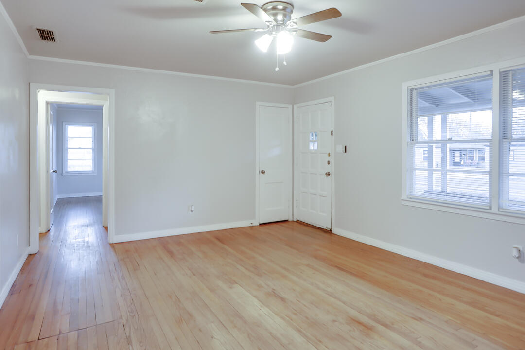 3414 24th Street Lubbock, TX 79410 - Photo 4 of 18 a view of an empty room with wooden floor and a window