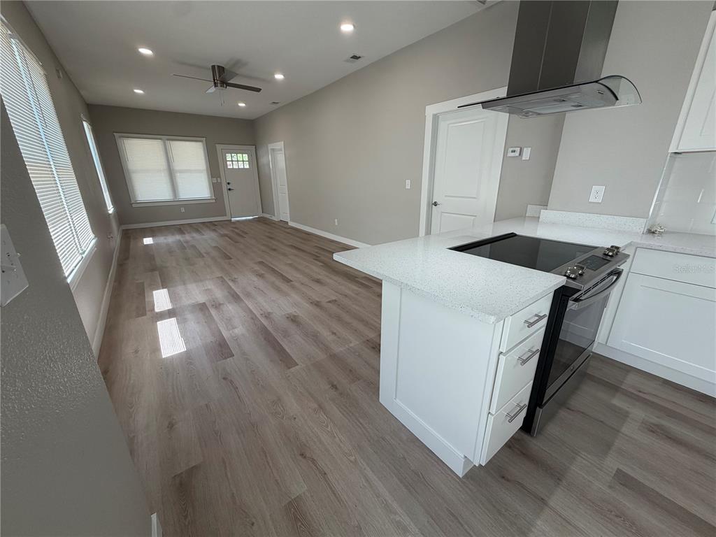 205 South 13th Street Palatka, FL 32177 - Photo 23 of 39 a kitchen with granite countertop a stove and a wooden floor