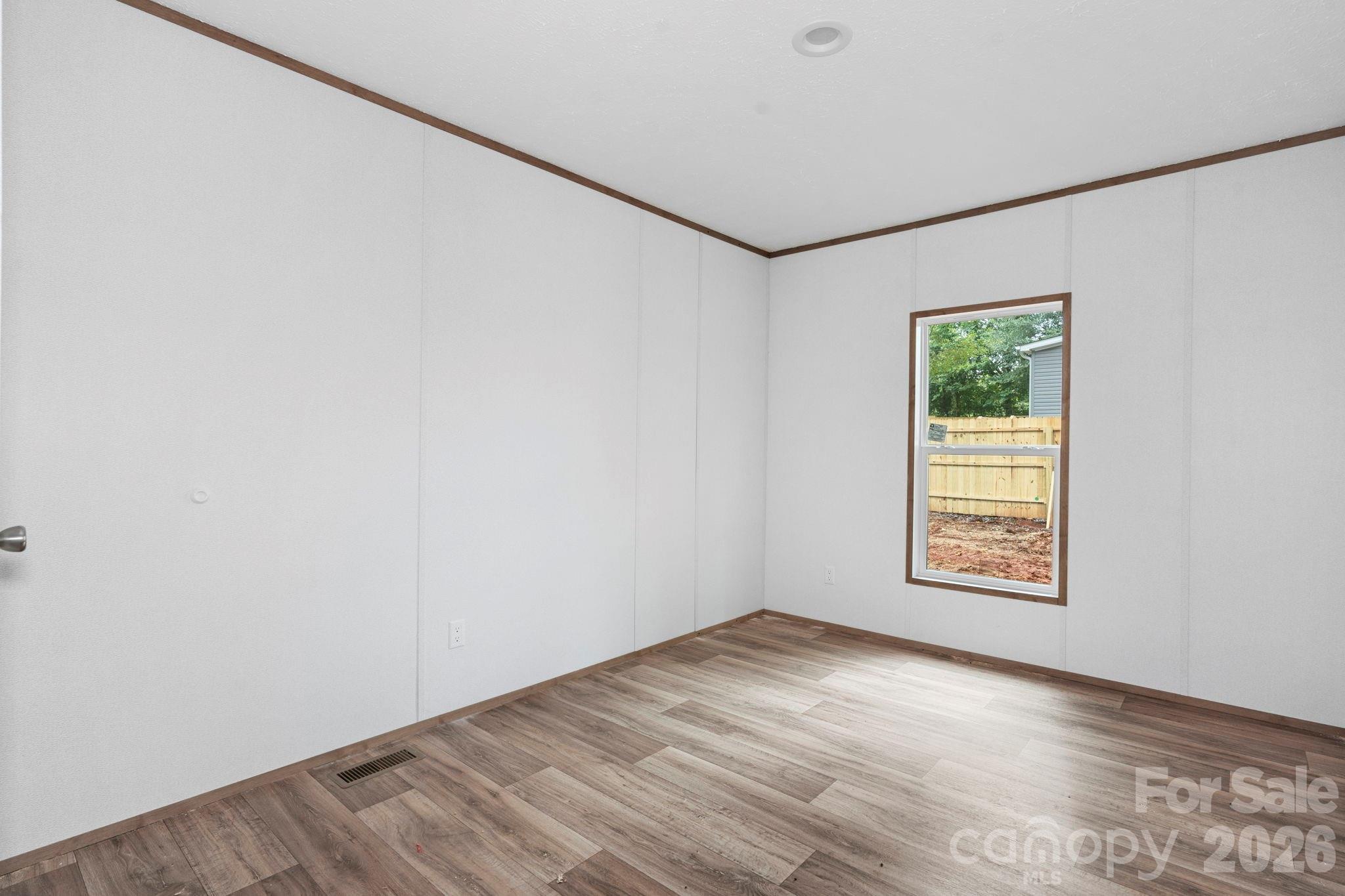 536 Lincolnview Road Lincolnton, NC 28092 - Photo 14 of 32 an empty room with wooden floor and windows