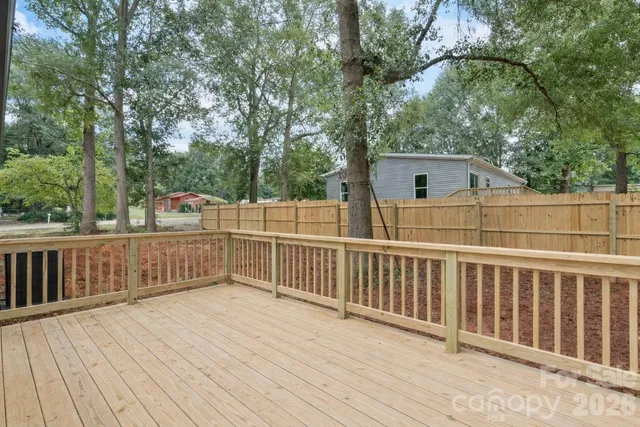 a backyard of a house with wooden fence and porch