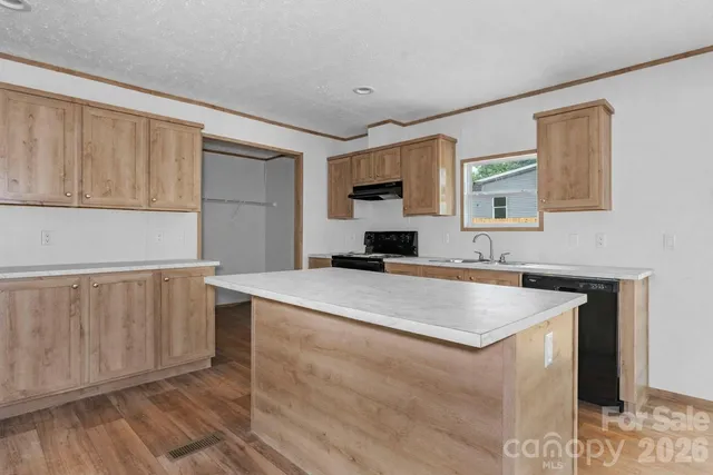 a kitchen with sink cabinets and a wooden floor