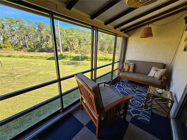a living room with furniture and a floor to ceiling window