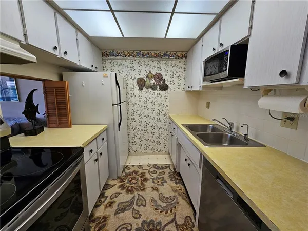 a kitchen with stainless steel appliances a sink stove and cabinets