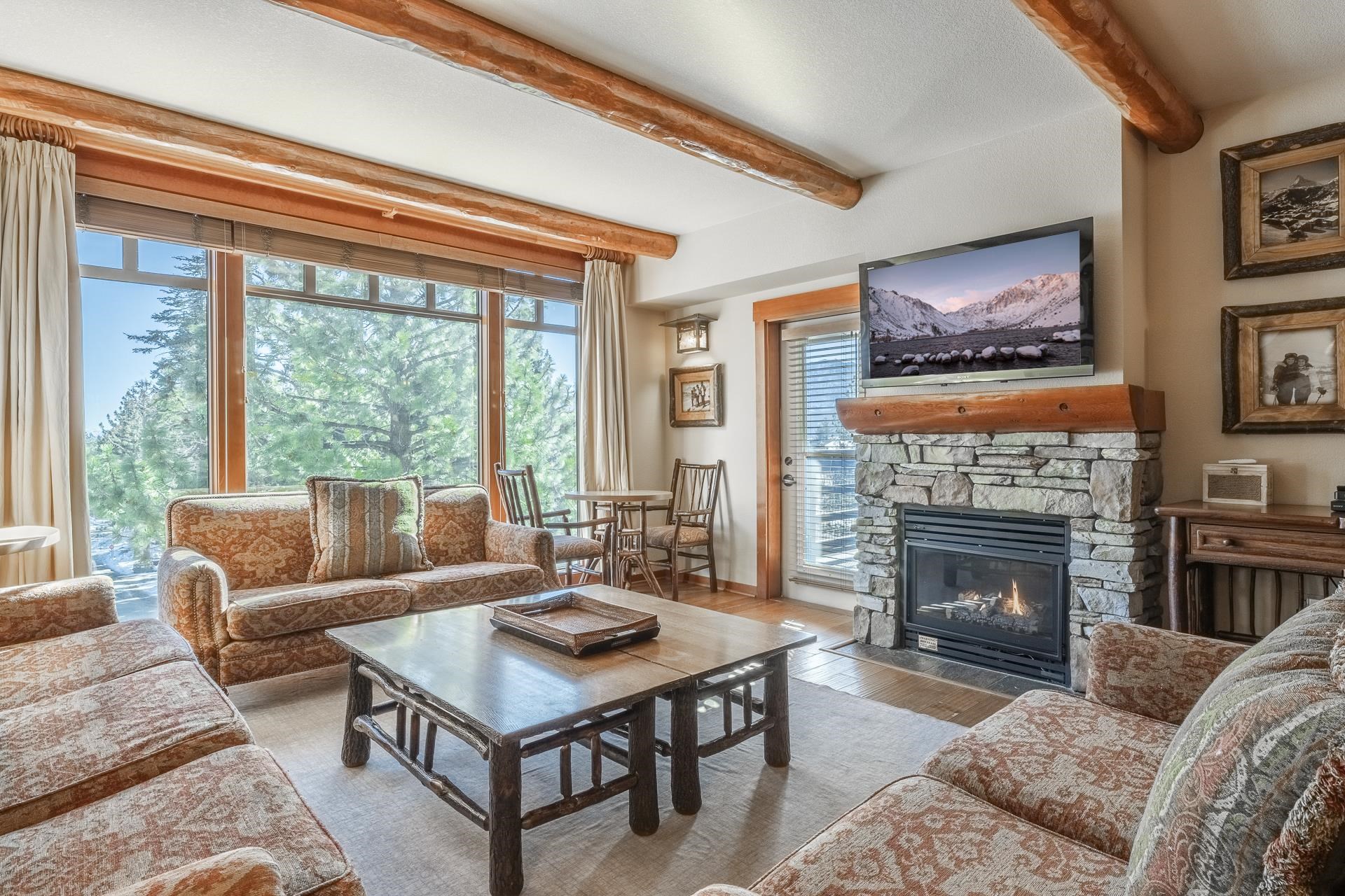 a living room with furniture a large window and a fireplace